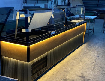 Amber LED aydınlatmalı, siyah ve ahşap kombinasyonlu, açılı camlı modern çiğköfte soğutma dolabı ve meze tezgahı