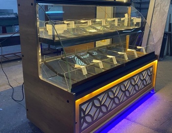 Ahşap gövdeli, lazer kesim motifli dekoratif ön panelli, amber ve mavi LED aydınlatmalı, cam bölmeli modern kuruyemiş vitrini