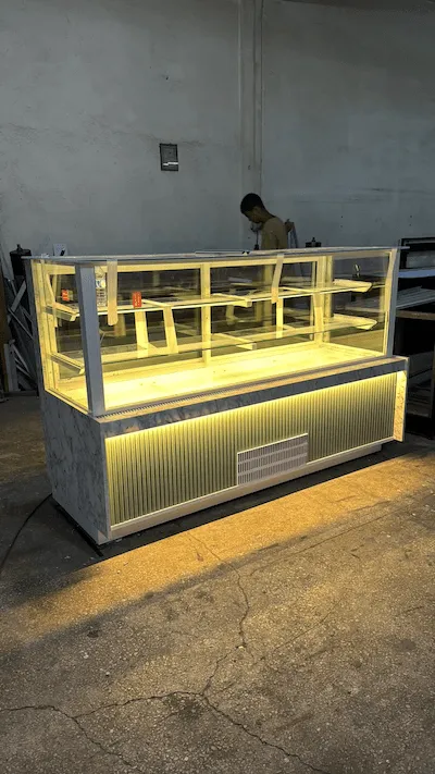 Beyaz mermer kaplamalı, gold sarı detaylı, led aydınlatmalı, modern pasta ve tatlı teşhir dolabı