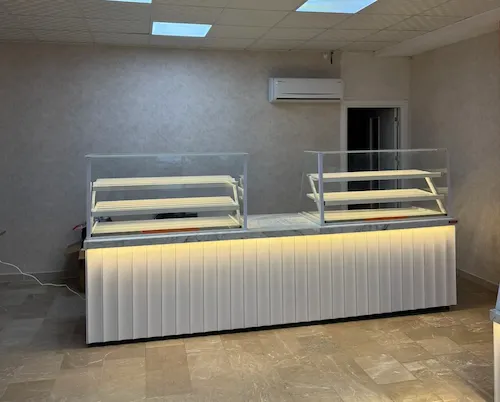 Beyaz oluklu panelli, beyaz mermer tablalı, çift cam vitrinli modern unlu mamuller ve pasta teşhir tezgahı